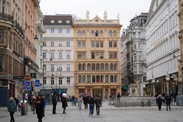 A bustling street scene in Vienna, featuring historic architecture and a Louis Vuitton store. Geschäftslokale auswählen: Lage, Frequenz und Vertragsprüfung